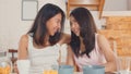 Asian Lesbian lgbtq women couple have breakfast at home, Young Asia lover female feeling happy drink juice, corn flakes cereal and