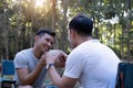 Asian LGBTQ couple drinking coffee in a romantic camping tent. LGBTQ couple drinking coffee in a camping tent, enjoying