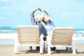 Asian Lifestyle senior couple raise hands and sitting on the beach happy in love romantic and relax time. Royalty Free Stock Photo