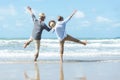 Asian Lifestyle senior couple walking chill and jumping on the beach happy Royalty Free Stock Photo