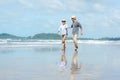 Asian Lifestyle senior elderly couple running on the beach happy enjoy in love romantic and relax time.