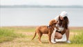 Asian lifestyle woman playing with dog golden retriever friendship so happy and relax outdoor the summer field meadow park. Royalty Free Stock Photo