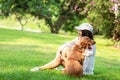 Asian lifestyle woman playing and hug young golden retriever friendship dog in outdoor Royalty Free Stock Photo