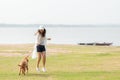 Asian lifestyle woman playing and running  with golden retriever friendship dog in sunrise outdoor the summer river park. Royalty Free Stock Photo