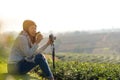 Asian lifestyle women wearing sweater relax, sitting  and drinking hot coffee or tea with camera outdoor Royalty Free Stock Photo