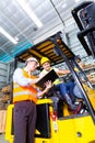 Asian lift truck driver and foreman in storage Royalty Free Stock Photo