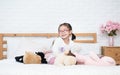 Asian little adorable girl sit in bed among many cute doll with happy and small at home Royalty Free Stock Photo