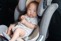 Asian little baby fastened with security belt in safety car seat Royalty Free Stock Photo