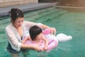 Asian little baby girl swimming and wear rubber ring in pool, Mother holding daughter for safety support, Living lifestyle family Royalty Free Stock Photo