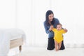 Baby taking first steps learning to walk with mother