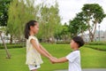 Asian little boy and girl child with hand in hand while play together in the garden. Asian Children in green park Royalty Free Stock Photo