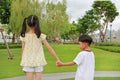 Asian little boy and girl child with hand in hand while play together in the garden. Asian Children in green park Royalty Free Stock Photo