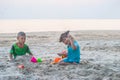 Asian little boy and girl are playing together on the sandy beach. Royalty Free Stock Photo
