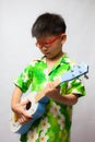 Asian little boy playing ukulele Royalty Free Stock Photo