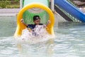 Asian little boy playing water slide at water park having fun. Royalty Free Stock Photo