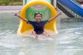 Asian little boy playing water slide at water park having fun on vacation. Royalty Free Stock Photo