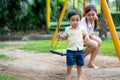 Asian little boy stand and look at camera after play swing with his mother in garden Royalty Free Stock Photo