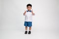 Asian little boy in student uniform with shows two fingers sign on white background.