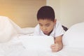 Asian little boy using tablet computer in bed. Royalty Free Stock Photo