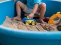 Asian little child boy hand playing car toy and sand in sandbox outdoor Royalty Free Stock Photo