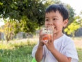 Asian little child boy holding glass of orange juice with smiling happy face Royalty Free Stock Photo