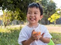 Asian little child boy holding glass of orange juice. Royalty Free Stock Photo