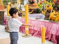 Asian little child boy light incense joss stick.