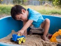 Asian little child boy playing car toy and sand in sandbox outdoor Royalty Free Stock Photo