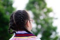 Asian little child girl with black hair braid turned her back to the camera. Children wear school uniforms and wear glasses. Royalty Free Stock Photo