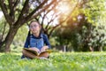 Asian little child girl with book in the garden Royalty Free Stock Photo