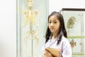 Asian little girl in doctor costume with skeleton in classroom a