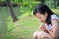 Asian little child girl feeling stressed,female worried bites finger nails in outdoor park,girl patient with nervous expression,