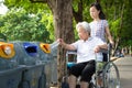 Asian little child girl or granddaughter and senior grandmother hand putting plastic water bottle in recycling bin,elderly tourist Royalty Free Stock Photo