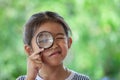 Asian little child girl looking through a magnifying glass Royalty Free Stock Photo