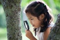 Asian little child girl looking through a magnifying glass Royalty Free Stock Photo