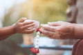 Asian little child girl pouring water on hands of elder senior Royalty Free Stock Photo