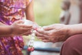 Asian little child girl pouring water on hands of elder senior Royalty Free Stock Photo