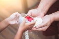 Asian little child girl pouring water on hands of elder senior Royalty Free Stock Photo