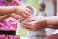 Asian little child girl pouring water on hands of elder senior Royalty Free Stock Photo