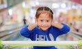 Asian little child girl sitting in the trolley during family shopping in the market Royalty Free Stock Photo