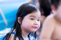 Asian little child girl was bored in the pool at home. She was in a bad mood from staying at home.