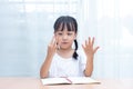 Asian little Chinese Girl doing mathematics by counting fingers Royalty Free Stock Photo