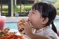Asian Little Chinese Girl Eating Burger and French fries