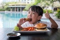 Asian Little Chinese Girl Eating Burger and Fried chicken Royalty Free Stock Photo