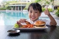 Asian Little Chinese Girl Eating Burger and Fried chicken Royalty Free Stock Photo