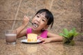 Asian little Chinese girl eating delicious cake