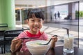 Asian little Chinese girl eating noodles soup Royalty Free Stock Photo