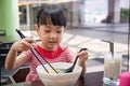 Asian little Chinese girl eating noodles soup Royalty Free Stock Photo