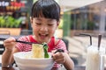 Asian little Chinese girl eating noodles soup Royalty Free Stock Photo