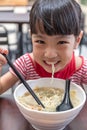 Asian little Chinese girl eating noodles soup Royalty Free Stock Photo